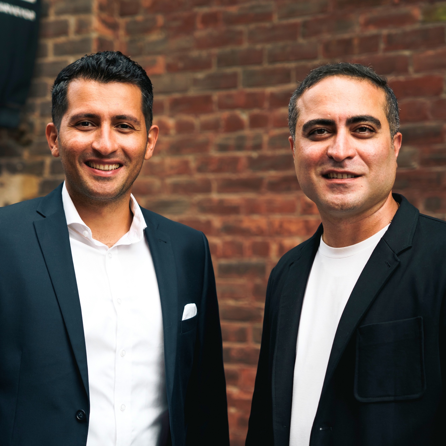 Alireza and Mehrdad Golestan together outside a Toronto brick building